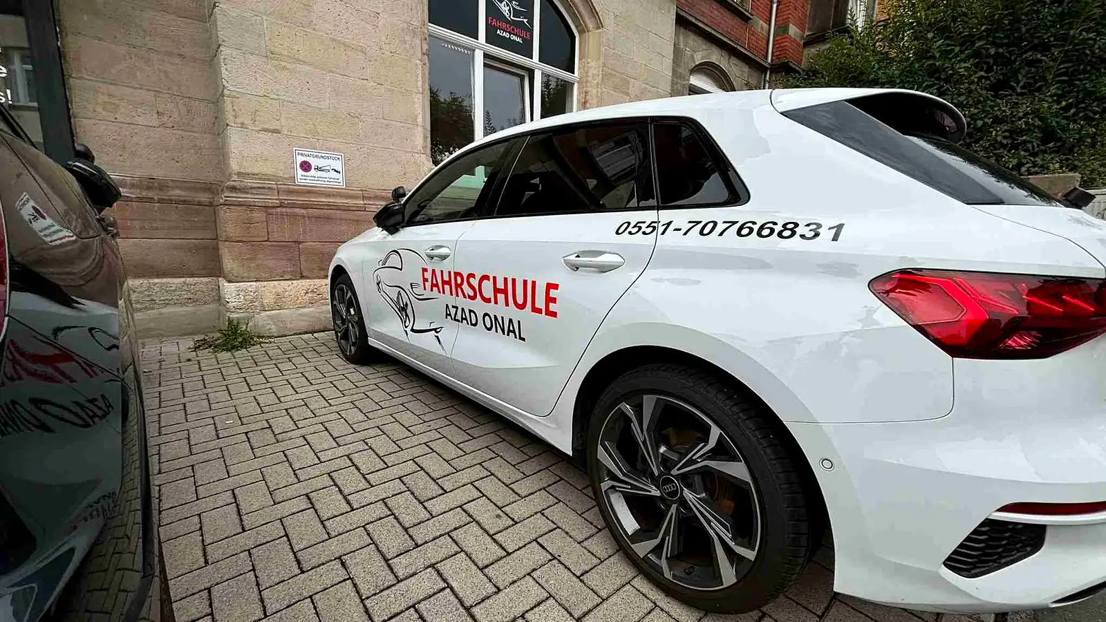 Weißer Audi A3 Sportback der Fahrschule AZAD mit Flottenbeschriftung