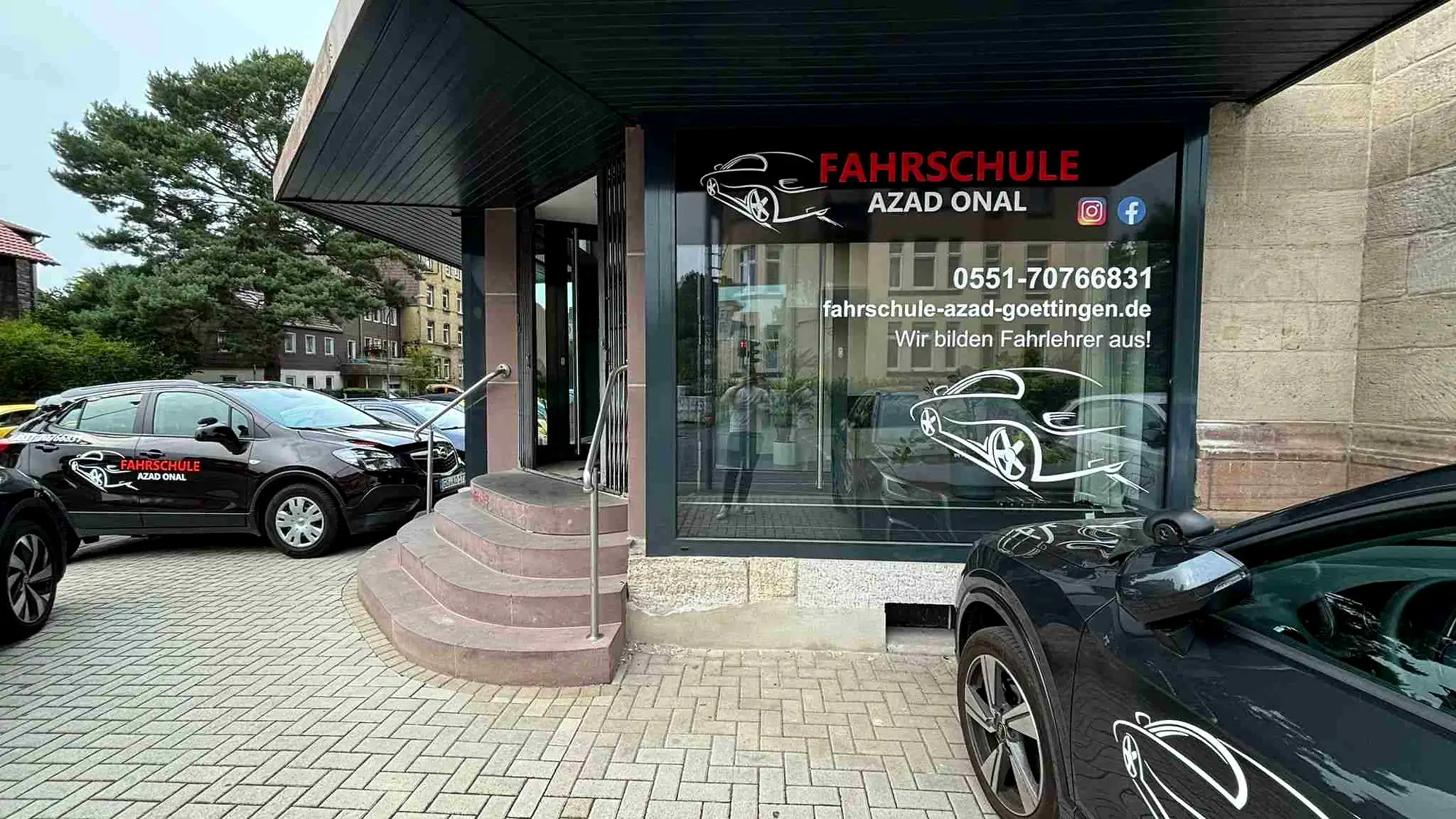 Ladenlokal der Fahrschule AZAD Onal am Rosdorfer Weg 23 in Göttingen mit beschrifteten Fahrschulwagen davor